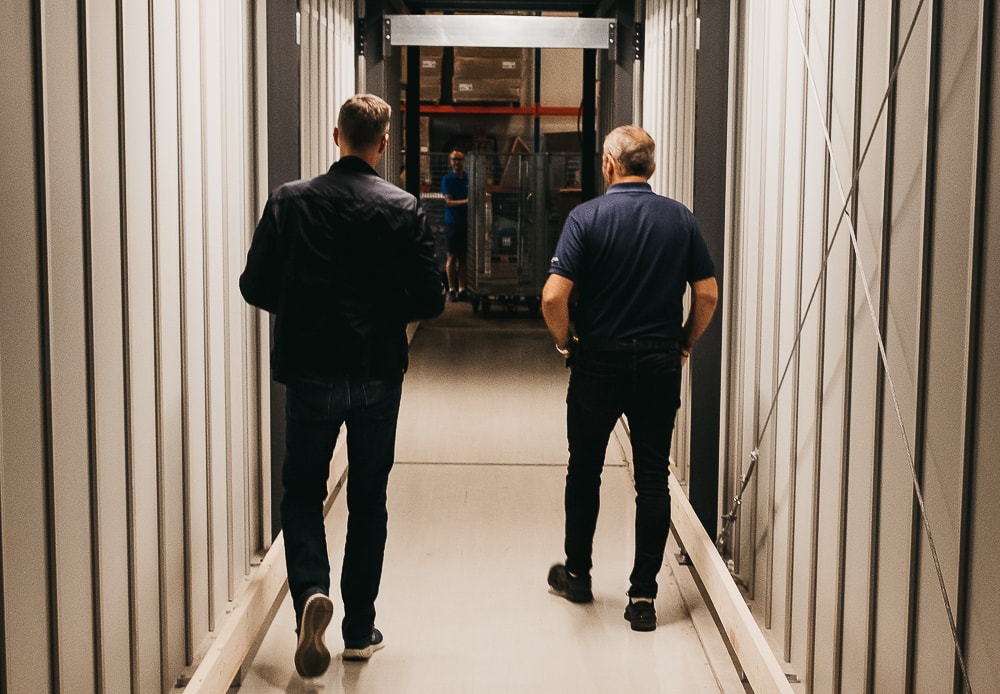 Oprichter, Trond Gule, en Element Logic Sales Manager, Øyvind Kollerud, lopen door de op maat gemaakte tunnel door AutoStore in GS Bildeler Oslo magazijn
